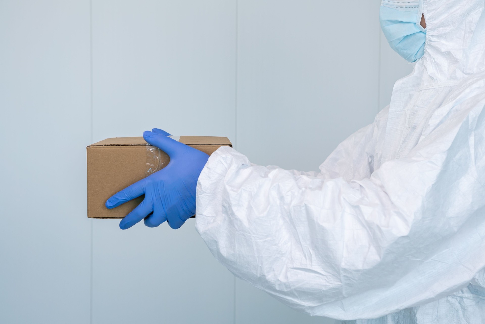 A male nurse in a protective suit PPE shows a box in the hospital. Coronavirus.